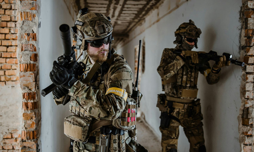 Two men playing milsim in military uniforms carrying BB rifles and milsim aciton cameras