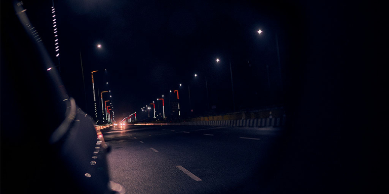 A street seen in a rear-view mirror, captured by the best Insta360 camera for car